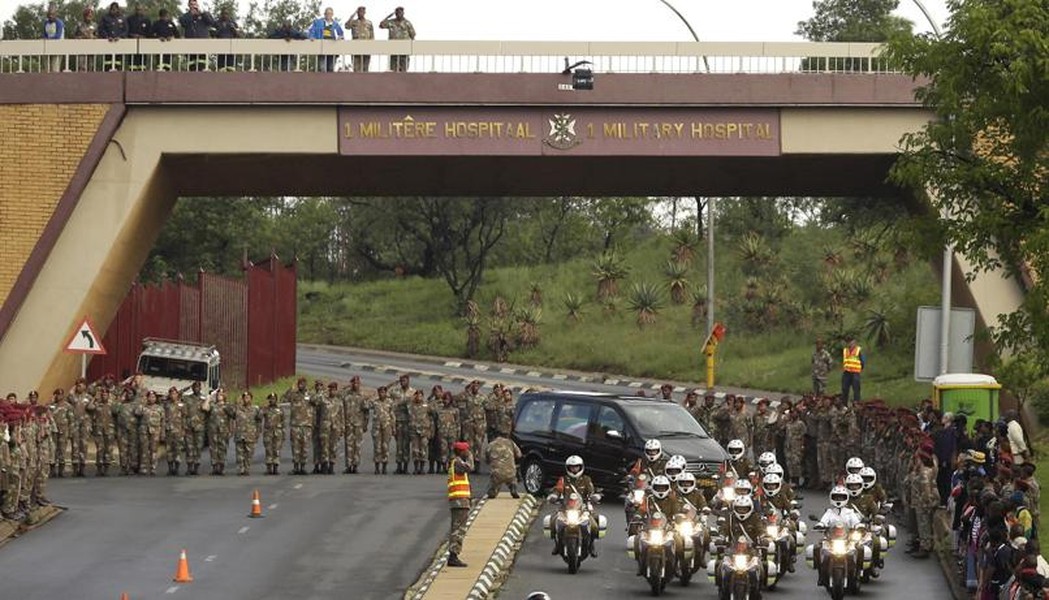 Lực lượng quân đội cùng nhân viên y tế đưa thi hài ông Mandela lên xe để chở tới khu Union Buildings ở Pretoria, chuẩn bị cho lễ viếng kéo dài 3 ngày.